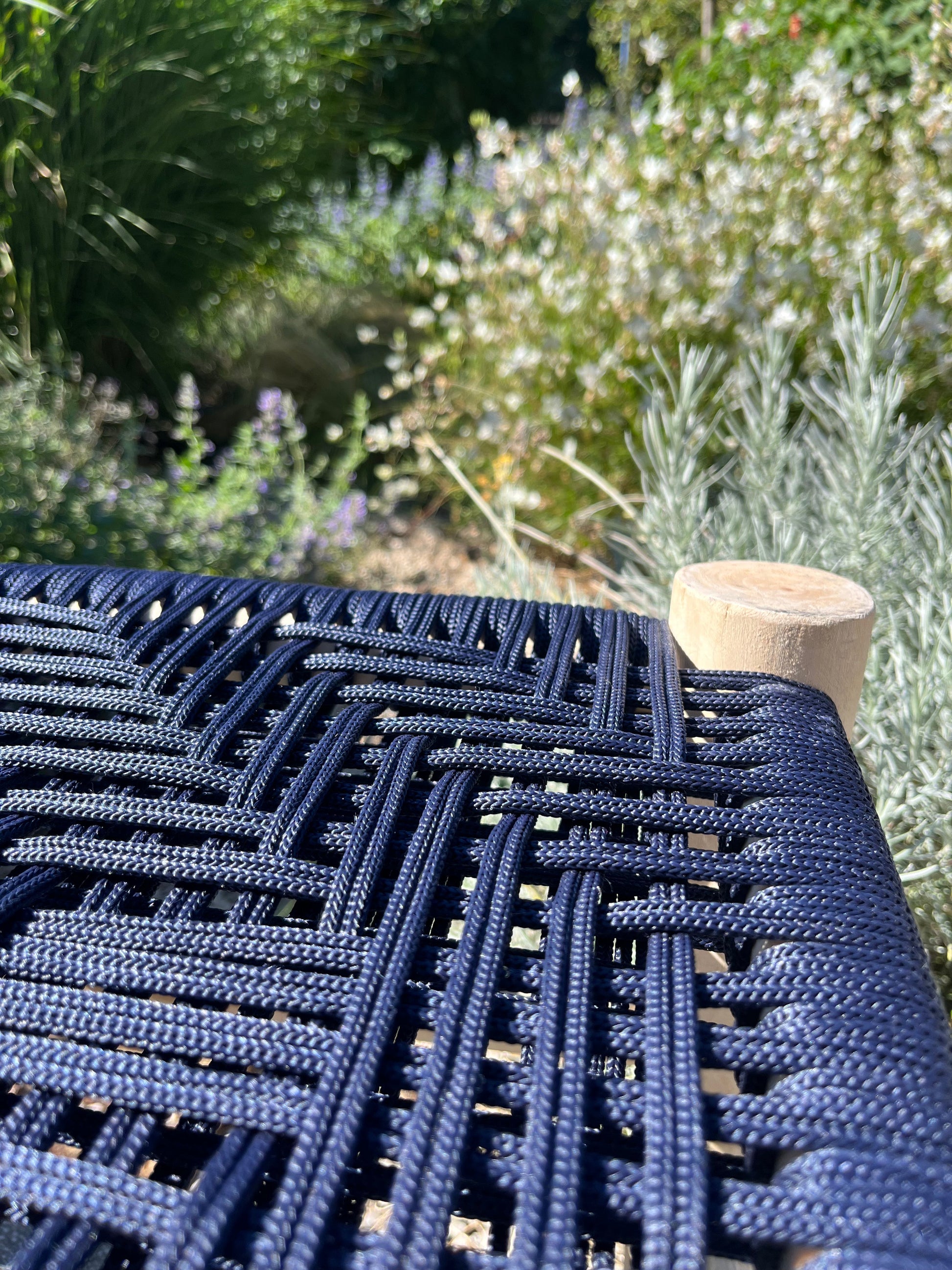 Détail du macramé bleu marine sur banc artisanal